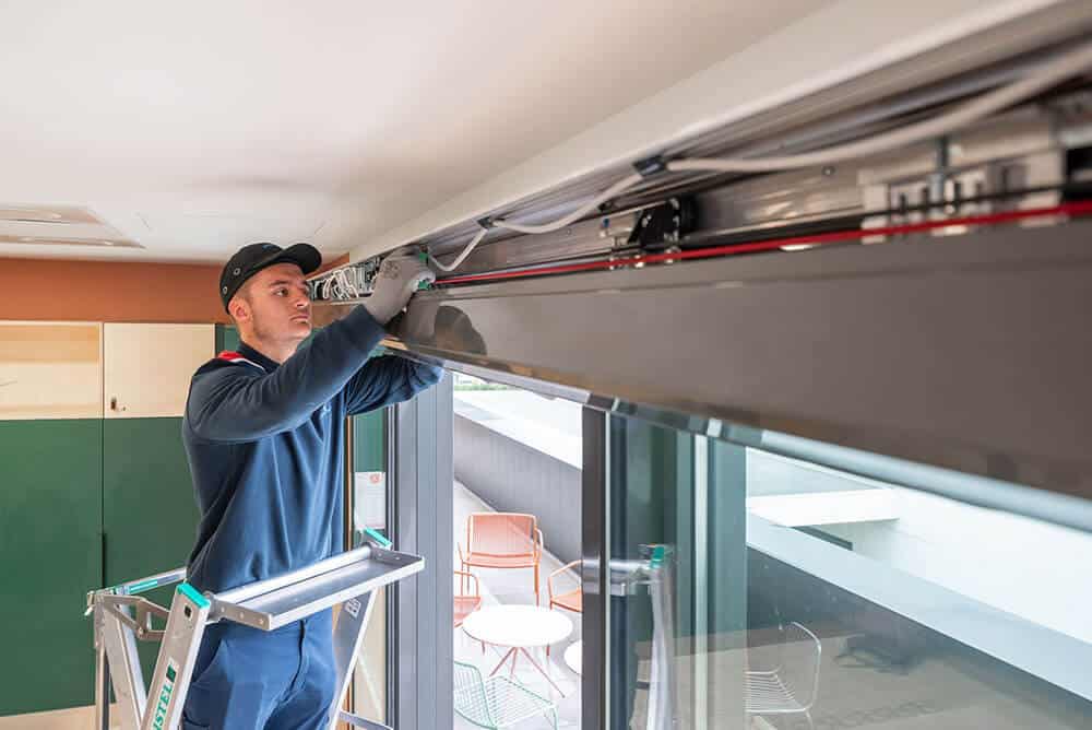 Technicien Portalp effectuant la maintenance d'une porte automatique